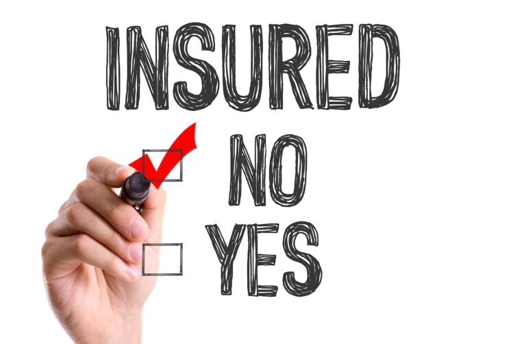 A hand is holding a marker, checking the "NO" box with a red checkmark on the health insurance coverage decision form with "INSURED" text above.
